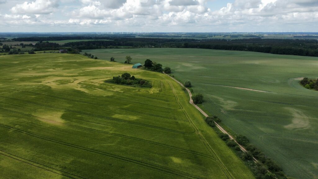 Expansive aerial landscape showing lush green agricultural fields in Germany during daytime.