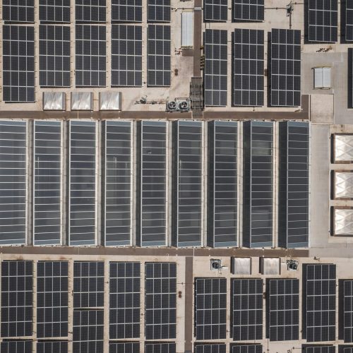 High-angle drone shot of rooftop solar panels showcasing renewable energy technology.